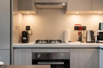 a kitchen with a stove and a counter top at 1BR plus Study Peaceful, Family-Friendly Community in Dubai