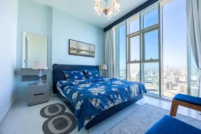 a blue bedroom with a bed and a large window at Miracle View in Dubai