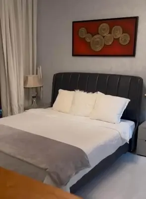 a bed with a black headboard in a bedroom at Miracle View in Dubai