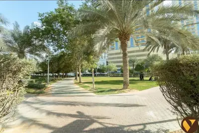 a street with palm trees in front of a building at Vogue JVC Jeewar Tower near Circle Mall, One Bedroom Apartment with Balcony and City View, Access to all Amenities in Dubai