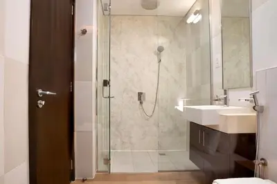 a bathroom with a shower and a sink and a toilet at Palm Jumeirah gem with direct beach access in Dubai