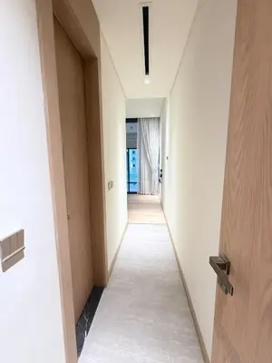 a hallway in a building with white walls and wooden doors at Modern 2BR House , Pool , 3 Baths, Balconies in Dubai