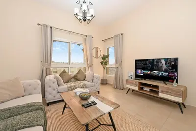 a living room with a couch and a tv at Bloomfields Homey 1BR in Al Ramth 37 in Dubai