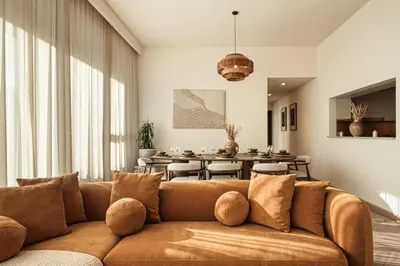 a living room with a brown couch and a table at Seraya Residences at Downtown Views 1 in Dubai
