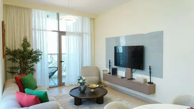 a living room with a couch and a tv at Stunning 2BR Canal View & Burj Khalifa 3 in Dubai