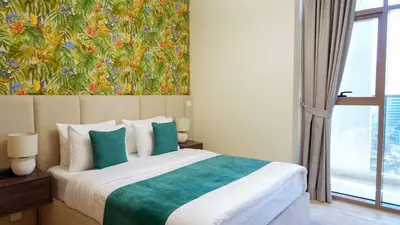 a bedroom with a bed with a painting on the wall at Stunning 2BR Canal View & Burj Khalifa 3 in Dubai