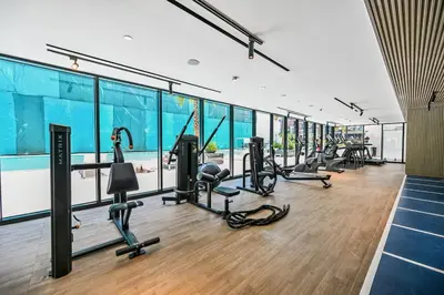 a gym with a row of treadmills and ellipticals at Stunning 1 br modern luxury residence at JVC in Dubai