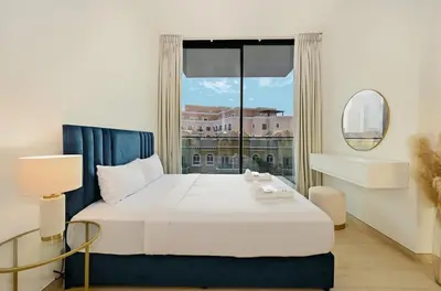 a bedroom with a bed and a large window at Stunning 1 br modern luxury residence at JVC in Dubai