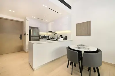 a kitchen with a counter and a table and chairs at Stunning 1 br modern luxury residence at JVC in Dubai