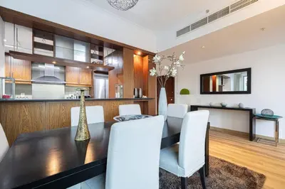a dining room with a table and white chairs at Burj Khalifa and Fountain View 3BR in Dubai