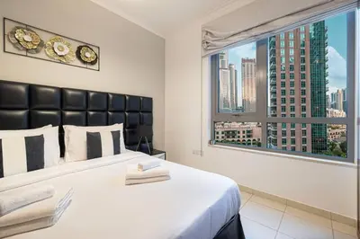 a bedroom with a large bed with a large window at Burj Khalifa and Fountain View 3BR in Dubai