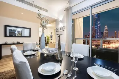 a dining room with a table and a view of the city at Burj Khalifa and Fountain View 3BR in Dubai