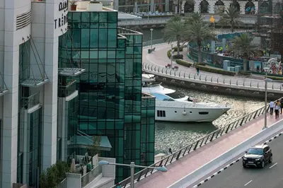 a boat in a river next to a building at 1Bedroom in Marina with Metro and Tram Access in Dubai