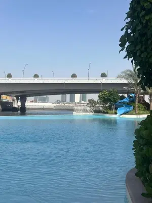 a bridge over a river with a bridge in the background at Vacationer l Contemporary 2 Bedroom l Pool, Gym, Private Beach Access in Dubai