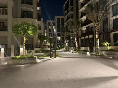 an empty courtyard with palm trees and buildings at night at Vacationer l Contemporary 2 Bedroom l Pool, Gym, Private Beach Access in Dubai