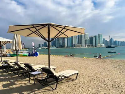 a group of chairs and an umbrella on a beach at Luxury studio with beach and pool access. in Dubai
