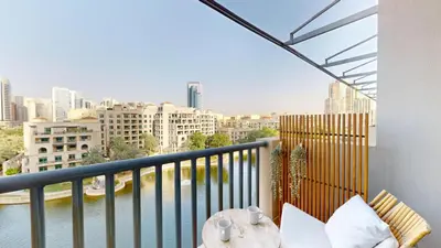 a balcony with a table and a view of the city at Vacationer l Spacious Studio l Canal View l The Greens in Dubai