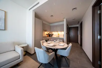 a dining room with a table and chairs and a couch at Modern 1BR with Guest Room l Sobha Hartland The Crest Tower C in Dubai