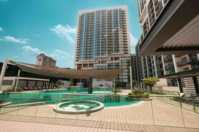 a large building with a swimming pool in a city at Modern 1BR with Guest Room l Sobha Hartland The Crest Tower C in Dubai