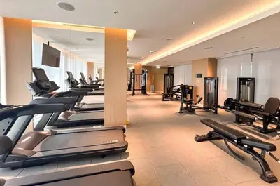 a gym with a row of treadmills and machines at Modern 1BR with Guest Room l Sobha Hartland The Crest Tower C in Dubai