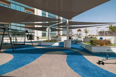 a building with a blue floor and a large umbrella at Modern 1BR with Guest Room l Sobha Hartland The Crest Tower C in Dubai