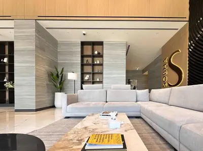a living room with a couch and a table at Modern 1BR with Guest Room l Sobha Hartland The Crest Tower C in Dubai