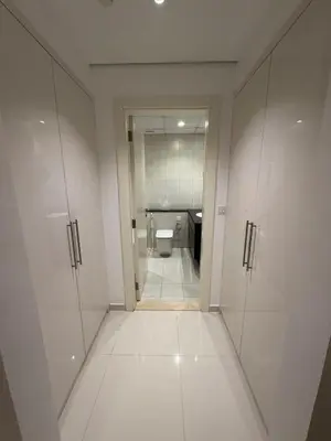 a bathroom with white cabinets and a toilet at Luxury Living in JVC 1BR Apartment in Dubai