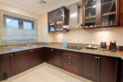a kitchen with wooden cabinets and a counter top at Full View Burj Khalifa and Fountains -Souk Al Bahar- Dream View holiday Home Rent in Dubai
