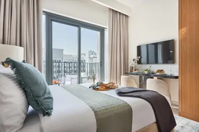 a hotel room with a bed and a large window at Frank Porter - Azizi Mirage 1 in Dubai