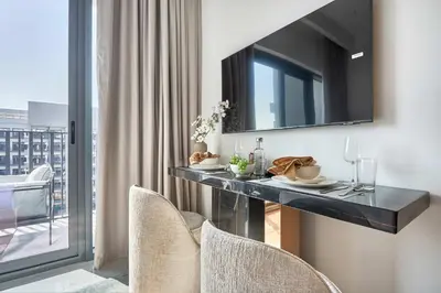 a dining table in a room with a mirror at Frank Porter - Azizi Mirage 1 in Dubai