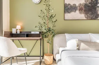 a living room with a couch and a table with a plant at Sleek Modern Studio with Direct view of Dubai Skyline - Farhad Azizi Residence, Al Jaddaf by Deluxe Holiday Homes in Dubai