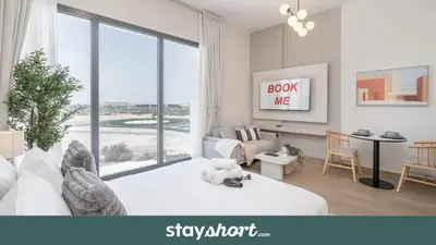 a bedroom with a bed and a living room at StayShort - Spacious Studio in Town Square Sleeps 2 in Nadd Shubayḩ