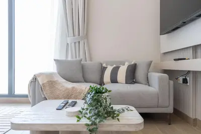 a living room with a couch and a coffee table at StayShort - Spacious Studio in Town Square Sleeps 2 in Nadd Shubayḩ