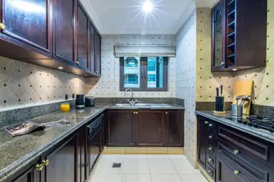 a kitchen with wooden cabinets and a sink at Luxury Old Town Fountain View 2BHK front of Dubai Mall in Dubai