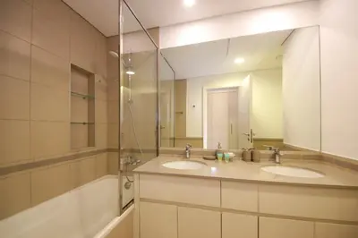 a bathroom with two sinks and a large mirror at Silk Valley - Green View Oasis: Stylish 2BR in Dubai’s Town Square in Dubai