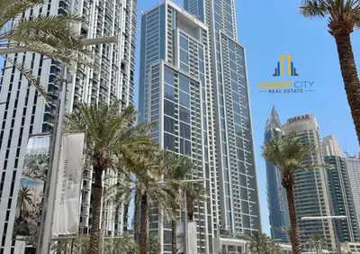 a group of palm trees in front of tall buildings at Premium 2BR Downtown Dubai Near Burj & Dubai Mall Hosted by Desert City Stays in Dubai