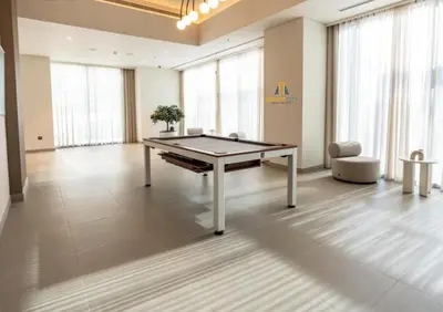 a ping pong table in a large room with windows at Premium 2BR Downtown Dubai Near Burj & Dubai Mall Hosted by Desert City Stays in Dubai