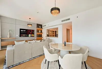 a living room with a couch and a table and chairs at Curated High-Floor 2BR Sofa Bed Marina Water View in Dubai