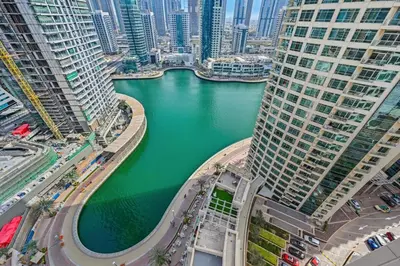 a view of a river between two tall buildings at Curated High-Floor 2BR Sofa Bed Marina Water View in Dubai