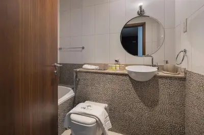 a bathroom with a sink and a toilet and a mirror at Chic Studio in Sports City Pool, Gym, Sauna in Dubai