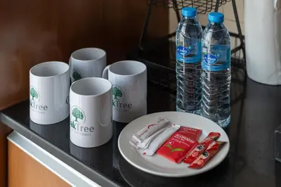 a table with cups and a plate of food and water at Chic Studio in Sports City Pool, Gym, Sauna in Dubai