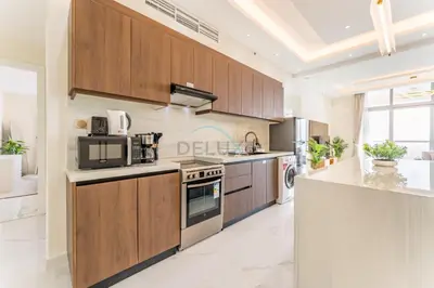 a large kitchen with wooden cabinets and a microwave at Walking Distance To JBR Beach, The Walk, And Marina Mall, With Easy Access To The Metro And The Vibrant Marina Nightlife - DEC Towers 2, Dubai Marina by Deluxe Holiday Homes in Dubai