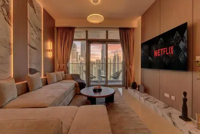 a living room with a couch and a large window at New Downtown Bldg Near Burj View with Infinity Pool and SkyGym in Dubai