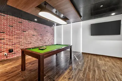 a pool table in a room with a brick wall at New Downtown Bldg Near Burj View with Infinity Pool and SkyGym in Dubai