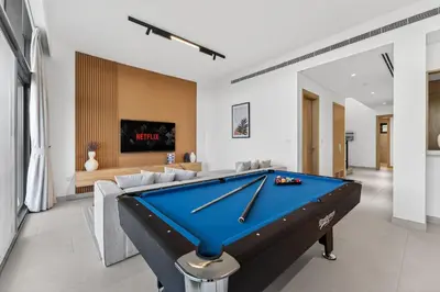 a pool table in a living room with a couch at New, Bright & Modern 4BR Villa in Tilal Al Furjan in Dubai
