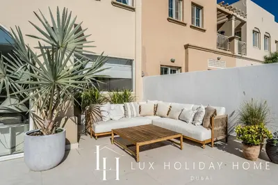 a patio with a couch and a coffee table at LUX The Serene Springs Villa 3 in Dubai