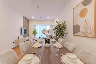a dining room with a wooden table and chairs at HAVN - 2 bedroom in Elite Residences, Dubai Marina in Dubai