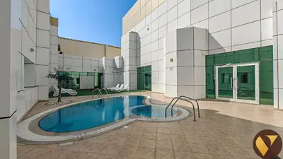 a swimming pool in front of a building at Vogue JLT Lake City Tower near Marina and JBR, Studio Apartment with Lake and City Skyline View, Access to all Amenities in Dubai