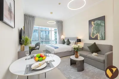 a living room with a bed and a couch and a table at Vogue JLT Lake City Tower near Marina and JBR, Studio Apartment with Lake and City Skyline View, Access to all Amenities in Dubai