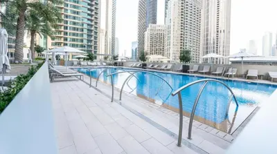 a swimming pool on top of a building with tall buildings at Exquisite 2BDR Retreat In Forte-33 in Dubai